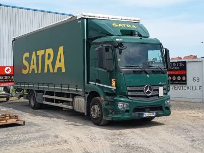 un camion vert garé devant un immeuble