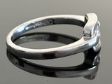 a silver ring with a diamond in it on a table