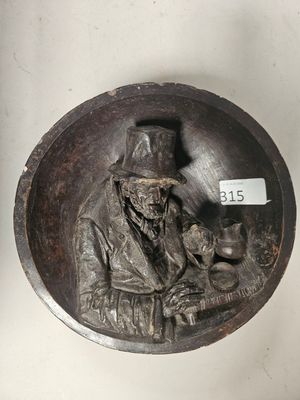 une plaque en bronze représentant un homme tenant un chat