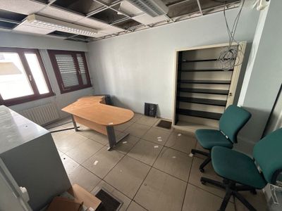 une image représentant une pièce avec un bureau et des chaises