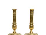 pair of antique brass candlesticks on a white background