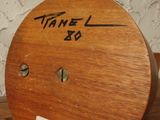 a wooden clock on a shelf with a name on it
