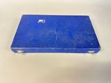 an old blue book sitting on top of a white table