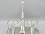 a silver plate with three glasses and a candle holder on it