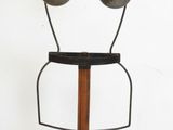 a metal sculpture of a woman ' s face on a wooden stand