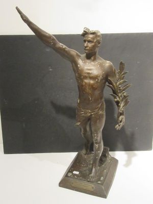 bronze statue of a man holding a plant in his right hand