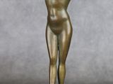 statue en bronze représentant une femme debout sur un socle, les mains derrière la tête