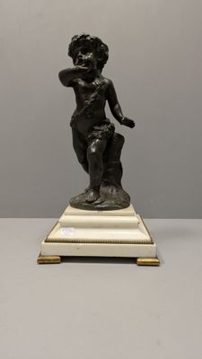 statue en bronze représentant un garçon, posée sur un socle en marbre