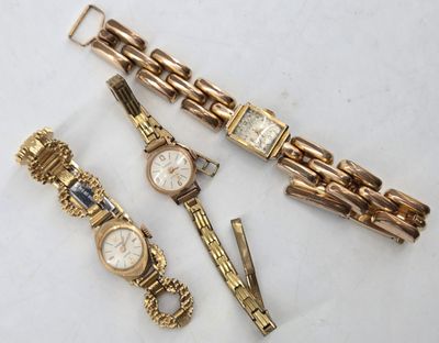 three watches and a bracelet are sitting on a white surface