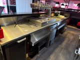 stainless steel counter top in a restaurant with a laptop on the counter