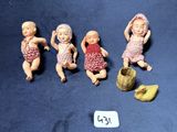 cinq figurines représentant des bébés assis sur une surface bleue