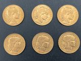 a close up of a bunch of gold coins on a black surface