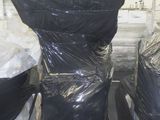 une pile de cuvettes de WC noires sur une palette