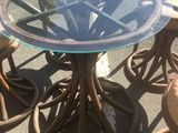 a glass table and four stools on the sidewalk