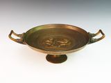 an image of a brass bowl with handles on a white surface