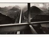 une photo en noir et blanc d'un train avançant sur les rails