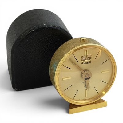 a small gold clock sitting on a black case