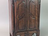 un petit meuble en bois surmonté d'une porte