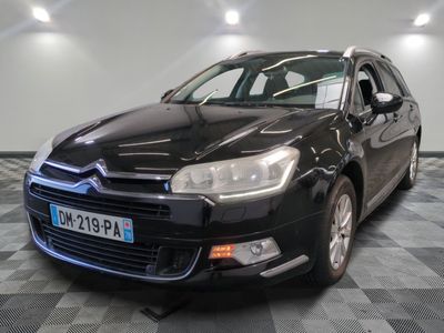 La Citroën noire est garée dans le garage, sur un sol à damier.