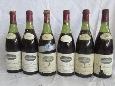six bouteilles de vin sont alignées sur une table