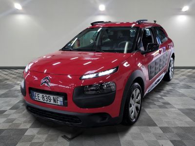 La Citroën rouge est garée sur le sol à damier du garage.