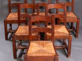 six chaises en bois sont alignées en rangée sur une surface grise