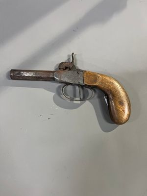 un gros plan d'une arme à feu accrochée au mur