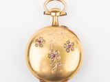 an image of a gold pocket watch with pink and white stones