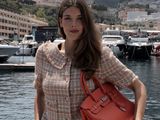 une femme qui se tient près de l'eau avec un sac