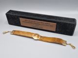 une photo d'un bracelet en bois muni d'un fermoir en or