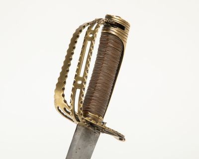 un gros plan d'une épée à la poignée dorée