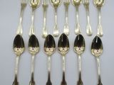 six silver spoons and two silver spoons on a white surface
