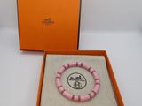 an orange box with a pink bracelet inside of it on a white surface