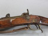 an old gun with a wooden handle on a white surface