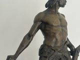 a bronze statue of a man holding a sword