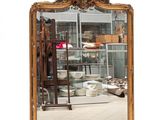 a mirror that is sitting on the floor in front of a shelf