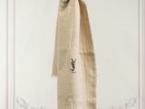 beige linen scarf hanging on a clothes line with a white wall in the background