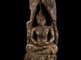 une image représentant une statue d'une personne assise sur une souche d'arbre