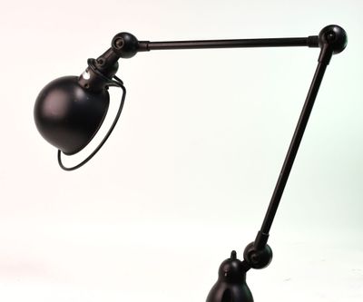 une image représentant une lampe de bureau noire sur fond blanc