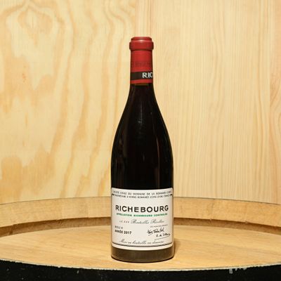 a bottle of wine sitting on top of a barrel