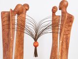 a sculpture of three people with a tree in the middle of them