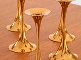 three gold candlesticks sitting on a wooden table