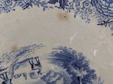 a blue and white plate with a picture of a man riding a horse