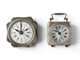 two clocks sitting side by side on a white surface