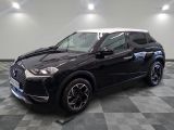 un 4x4 noir garé sur un sol en damier dans un garage
