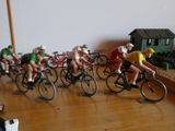 de nombreuses figurines représentant des personnes à vélo, posées sur une table