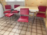 quatre chaises rouges et une table blanche dans une cuisine