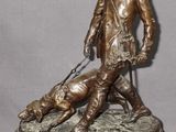bronze statue of a man with a dog and a cat on a marble base