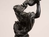 statue of a man holding a bottle of wine in his right hand