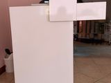 a white refrigerator sitting in the middle of a tiled floor